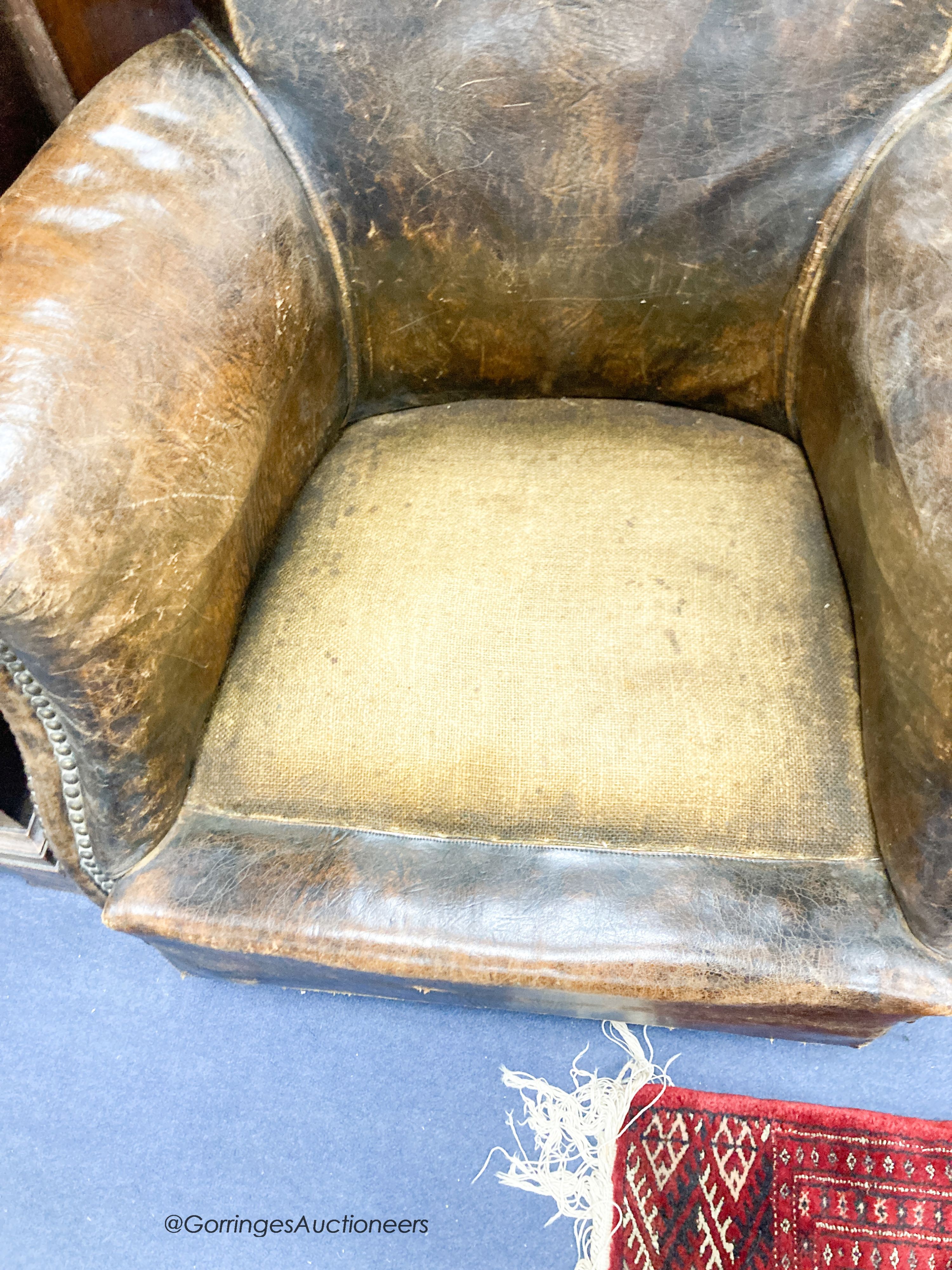 An early 20th century brown leather club armchair, width 78cm, depth 70cm, height 71cm